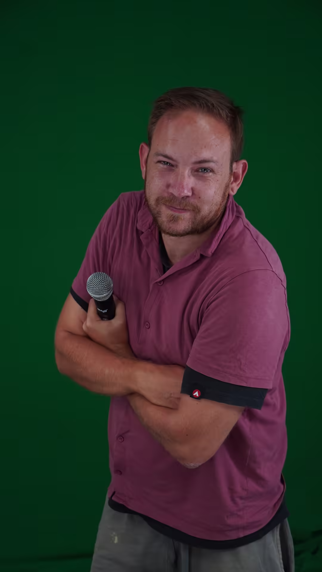 Fabian Vansant holding a microphone against a green backdrop