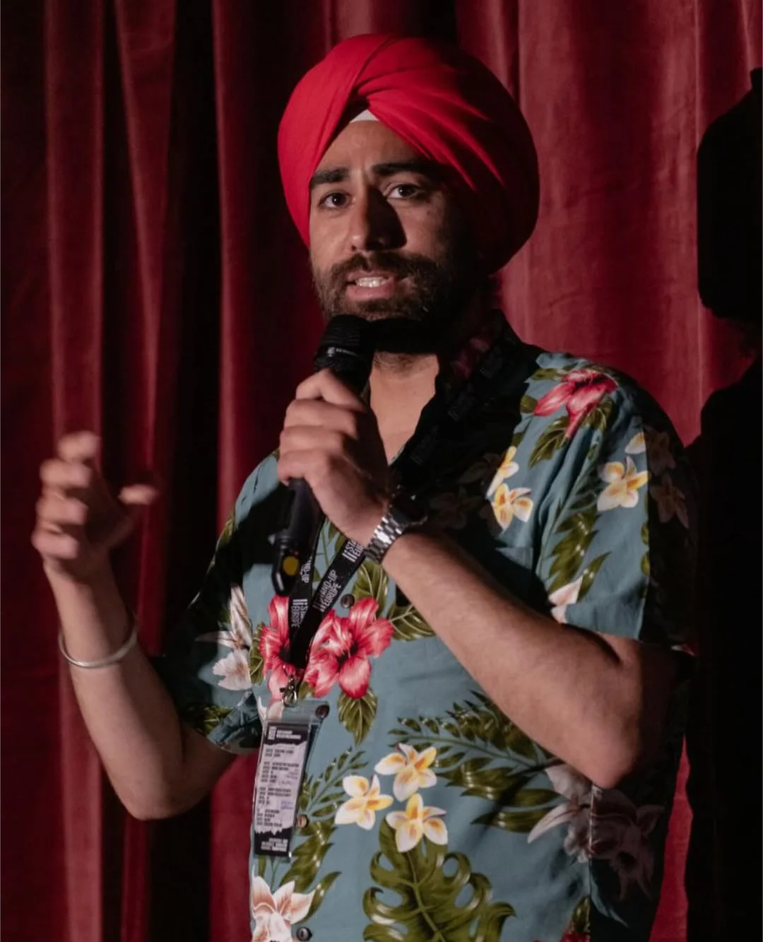 Liakatbir Singh Veghal performing stand-up with a microphone