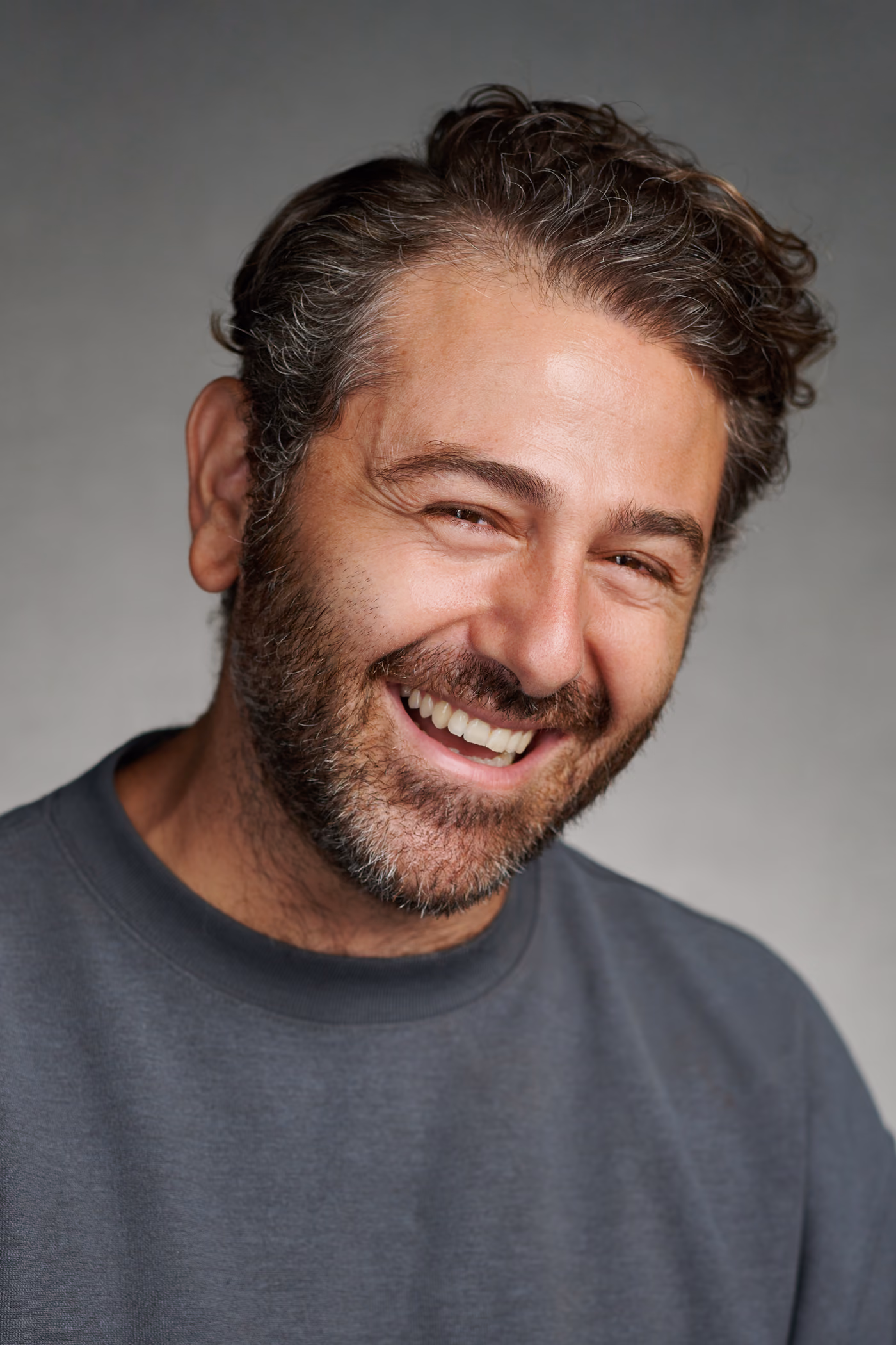 Close-up studio portrait of Yorkos laughing