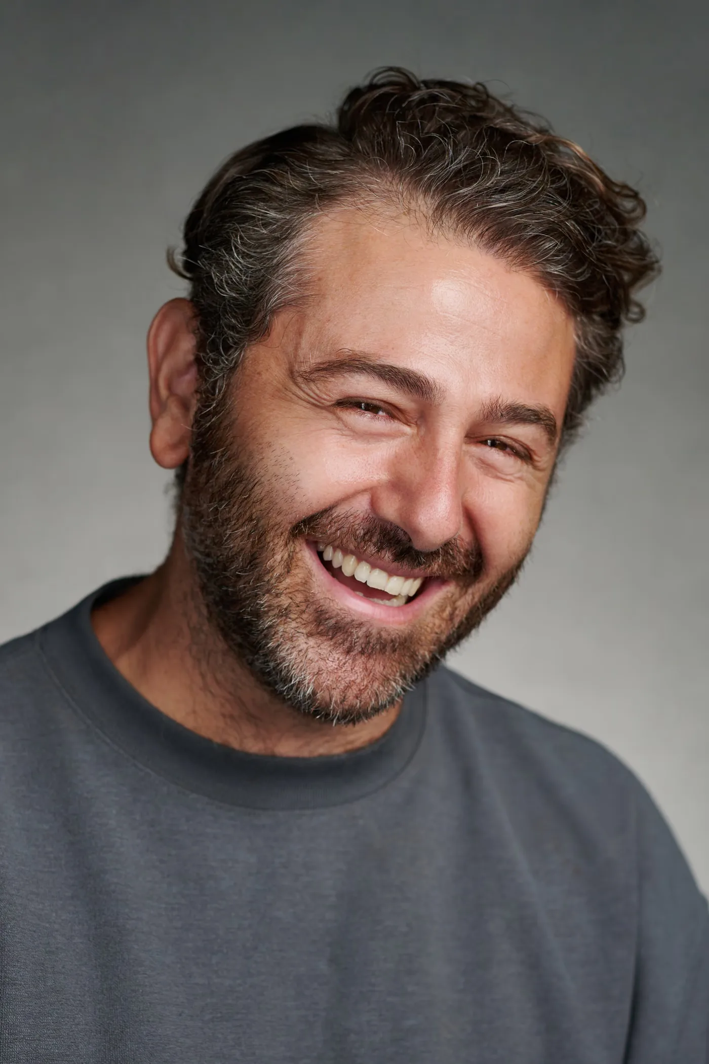 Giorgos Yorkos Kyriakou laughing in a studio portrait